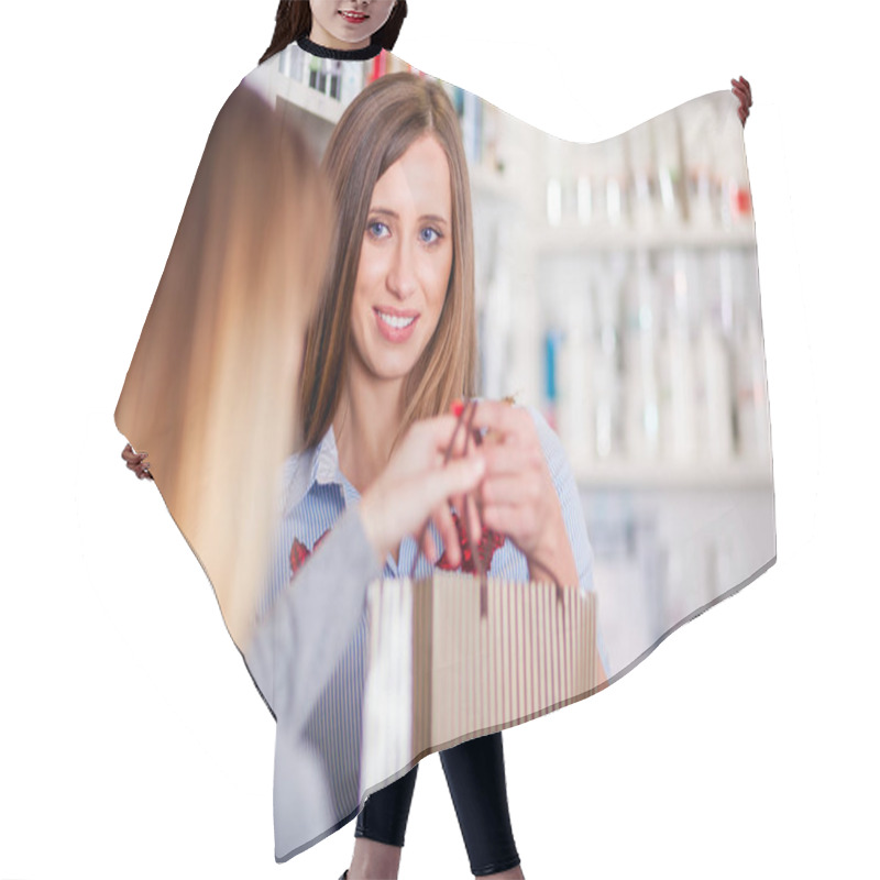 Personality  Saleswoman At Beauty Store Giving Shopping Bag Full Of Cosmetics To Customer Hair Cutting Cape