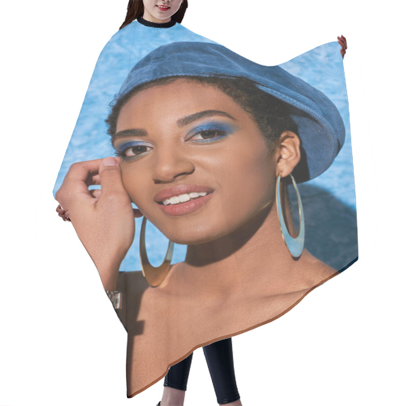 Personality  Portrait Of Young African American Woman With Bold Makeup, Beret And Golden Earrings Smiling At Camera And Posing On Blue Textured Background, Stylish Denim Attire Hair Cutting Cape