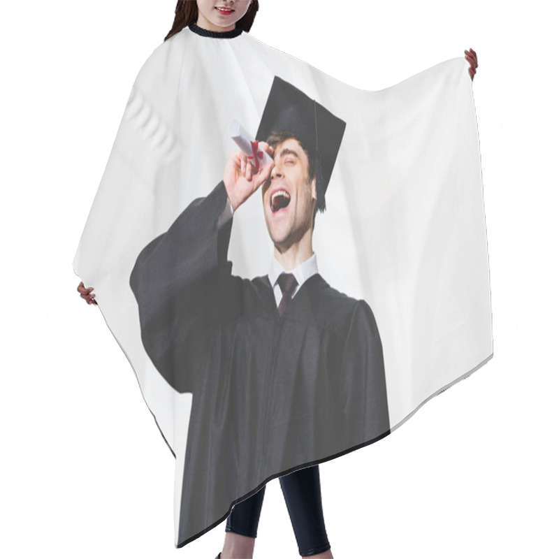 Personality  Low Angle View Of Happy Student In Graduation Gown Smiling While Holding Diploma Near Eye Hair Cutting Cape