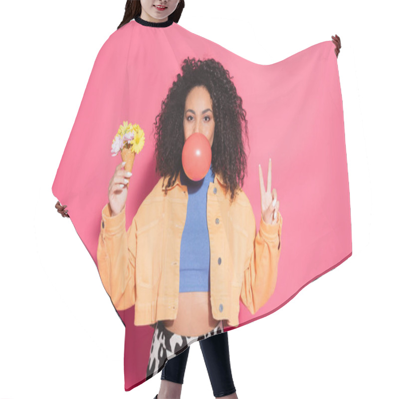 Personality  Curly African American Woman Blowing Bubble Gum, Holding Waffle Cone With Flowers And Showing Peace Sign On Pink Hair Cutting Cape