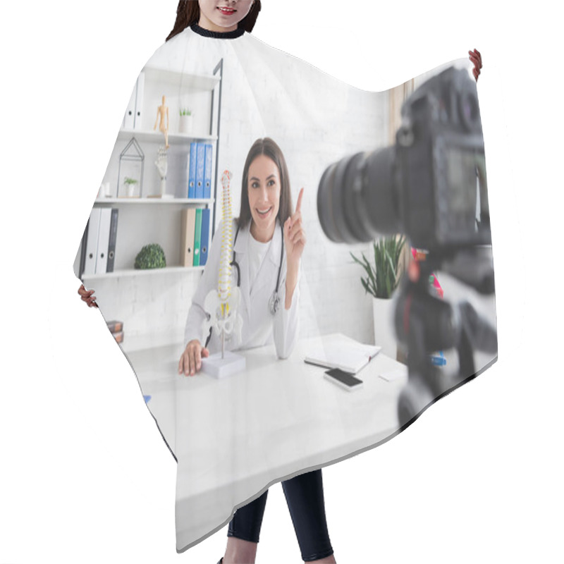 Personality  Positive Doctor Pointing With Finger Near Spinal Model And Blurred Digital Camera In Clinic  Hair Cutting Cape