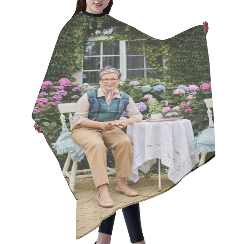 Personality  Cheerful Mature Woman Sitting In Garden At Tea Time Near House In England And Looking At Camera Hair Cutting Cape