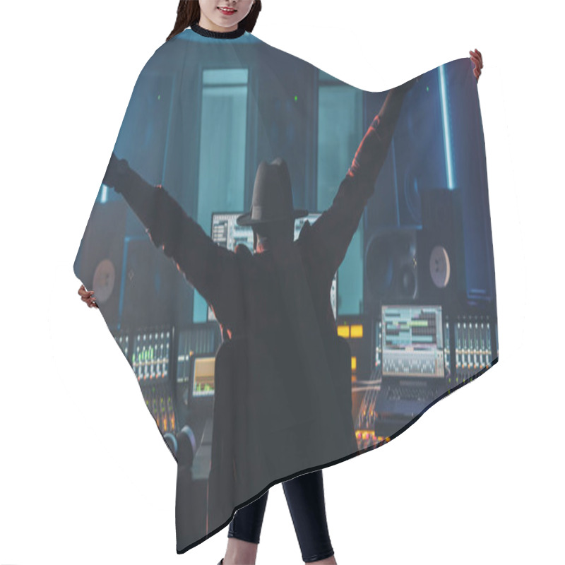 Personality  Artist, Musician, Audio Engineer, Producer In Music Record Studio, Uses Control Desk With Computer Screen Showing Software UI With Song Playing. Celebrates Success With Raised Hands, Dances. Back View Hair Cutting Cape