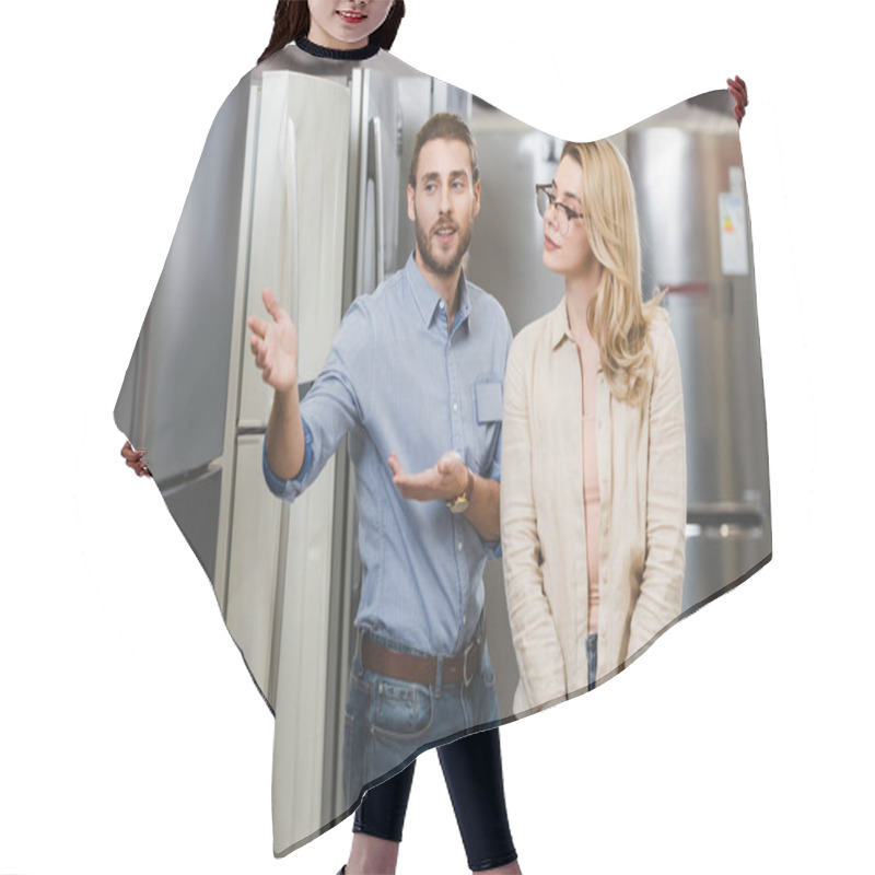 Personality  Consultant Pointing With Hands At Fridge And Talking With Woman In Home Appliance Store  Hair Cutting Cape