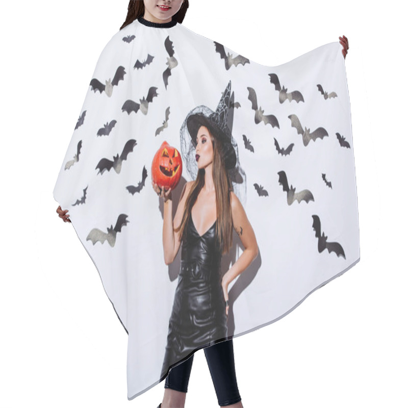 Personality  Girl In Black Witch Halloween Costume Holding Carved Spooky Pumpkin Near White Wall With Decorative Bats Hair Cutting Cape