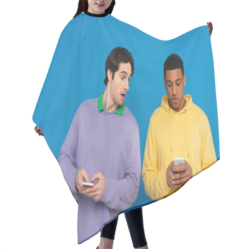 Personality  Curious Hipster Peeking At Smartphone Of African American Man Friend Isolated On Blue Hair Cutting Cape