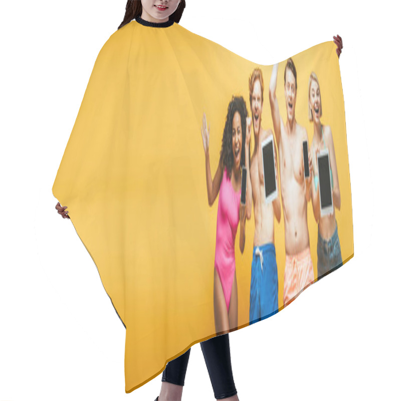 Personality  Horizontal Image Of Excited Multicultural Friends In Summer Outfit Showing Gadgets With Blank Screen On Yellow Hair Cutting Cape