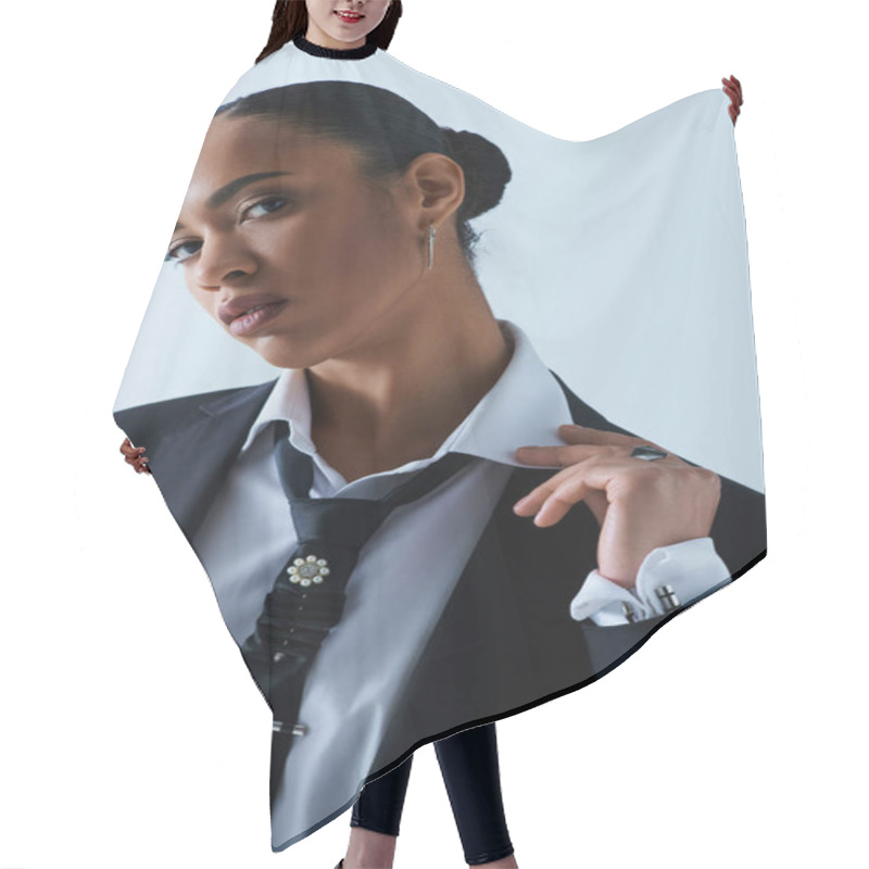 Personality  A Stylish Young African American Woman In Confidently Wears A Suit And Tie In A Studio Setting. Hair Cutting Cape