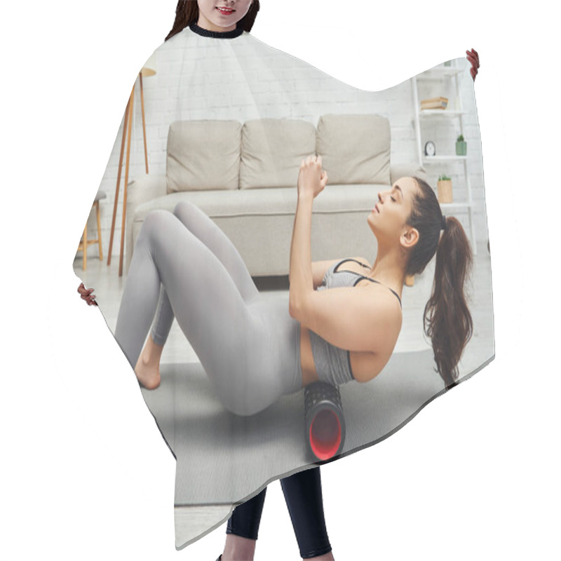 Personality  Side View Of Relaxed Young Woman In Activewear Massaging Small Of Back With Modern Roller Massager On Fitness Mat In Living Room At Home, Sense Of Tranquility And Promote Relaxation Concept Hair Cutting Cape