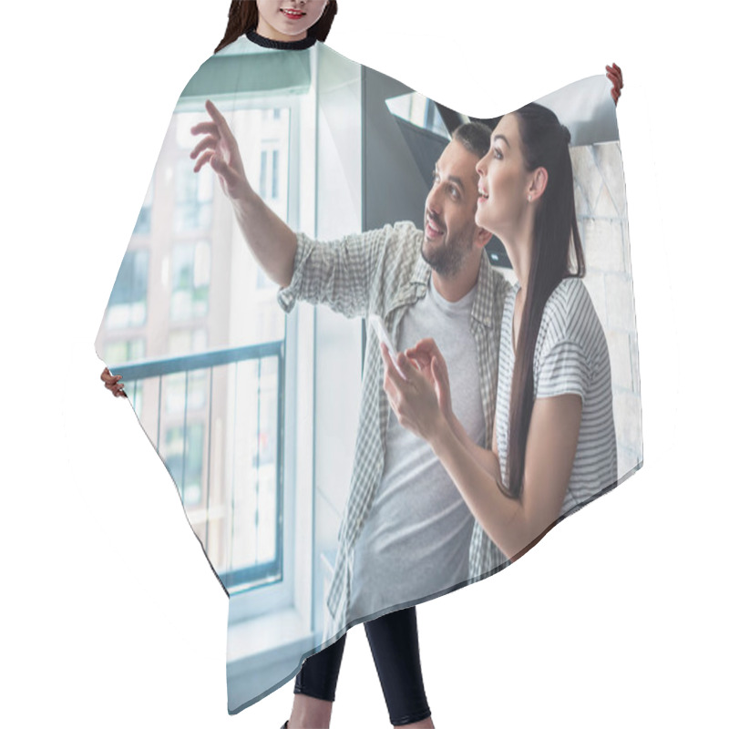 Personality  Side View Of Smiling Couple With Smartphone Looking Away Together In Kitchen, Smart Home Concept Hair Cutting Cape