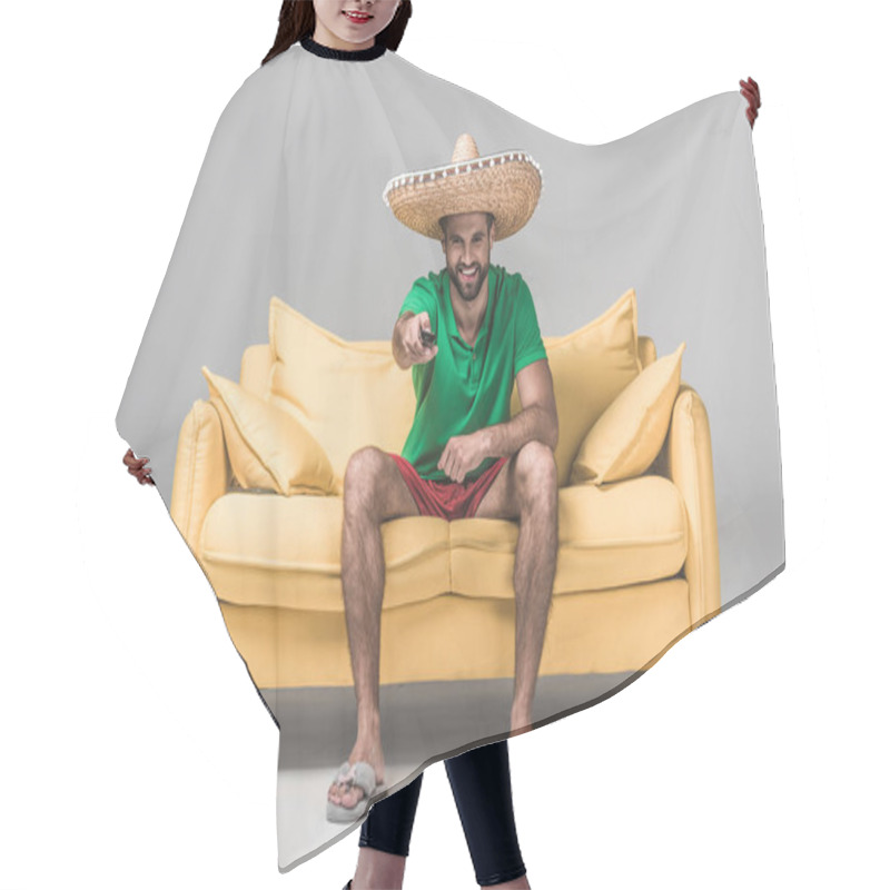 Personality  Smiling Bearded Man In Mexican Sombrero Watching TV With Remote Control On Yellow Sofa On Grey  Hair Cutting Cape