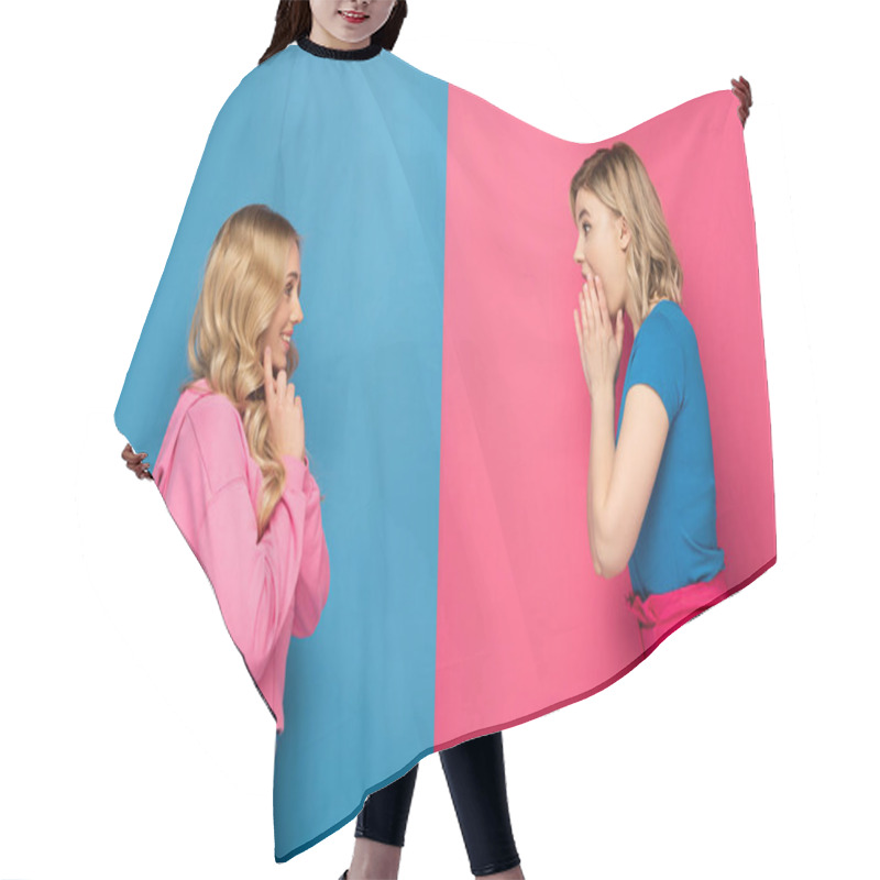 Personality  Side view of shocked and smiling blonde sisters looking at each other on pink and blue background hair cutting cape