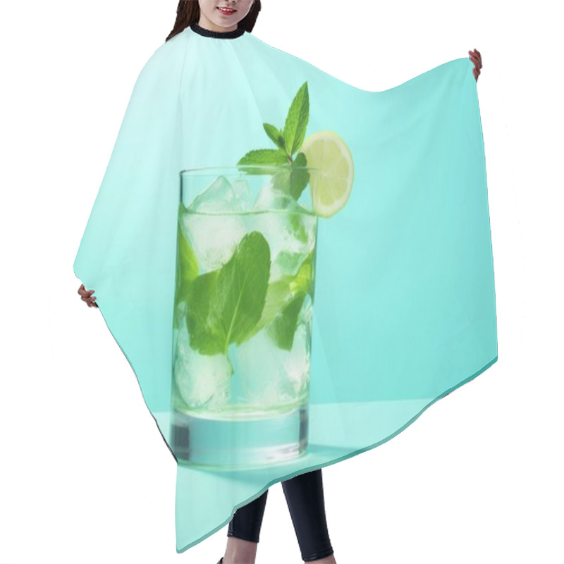 Personality  Refreshing Mint And Lemon Cocktail With Ice Against A Vibrant Teal Background. Hair Cutting Cape