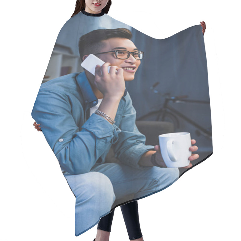 Personality  Smiling Young Asian Man In Eyeglasses Holding Mug And Talking By Smartphone Hair Cutting Cape