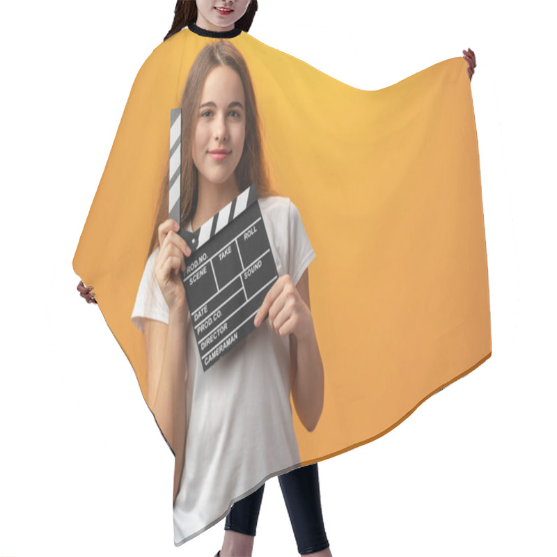 Personality  Smiling Teen Girl Holding Clapper Board Against Yellow Background Hair Cutting Cape