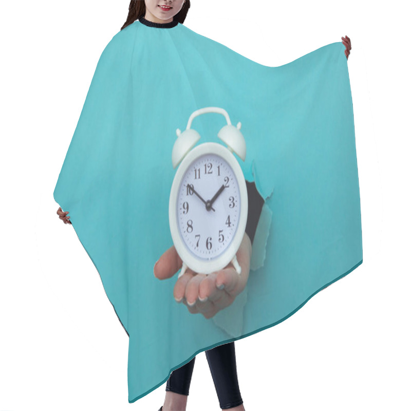 Personality  Woman Hand Holds Alarm Clock Through A Blue Paper Hole. Time Management And Deadline Concept Hair Cutting Cape