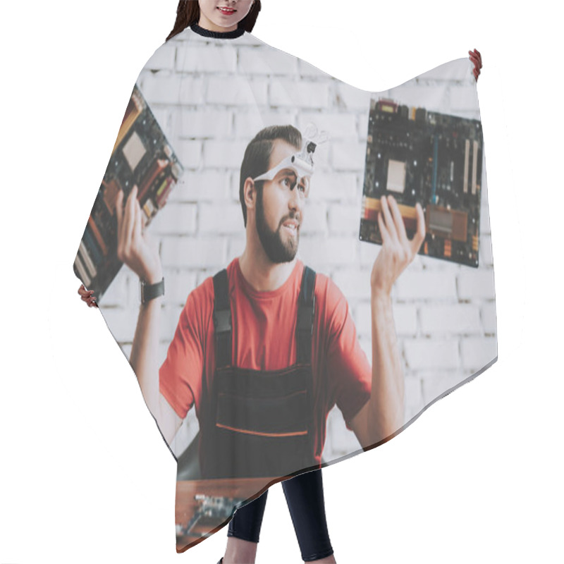 Personality  Young Man In Uniform With Broken Motherboards In Shop. Modern Workshop Concept. Manufacturing Instrument. Modern Tools Concept. Electronic Devices Concept. Mobile Device Hardware. Wooden Desk. Hair Cutting Cape