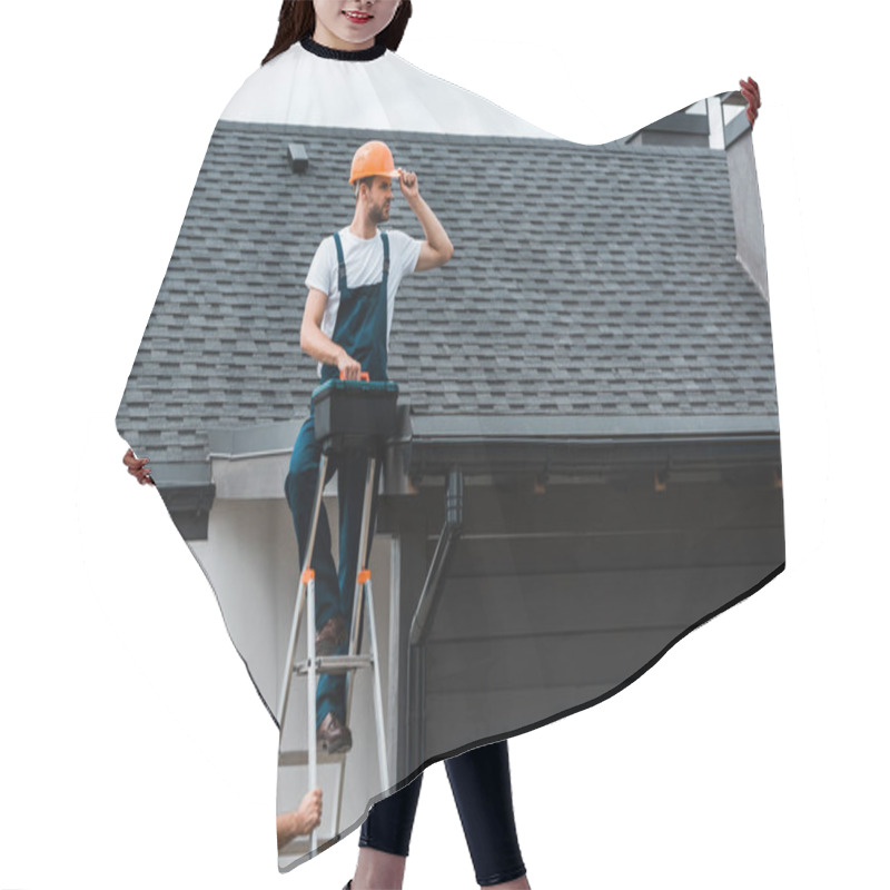 Personality  Handsome Repairman Sitting On Roof And Holding Toolbox Near Coworker In Helmet  Hair Cutting Cape