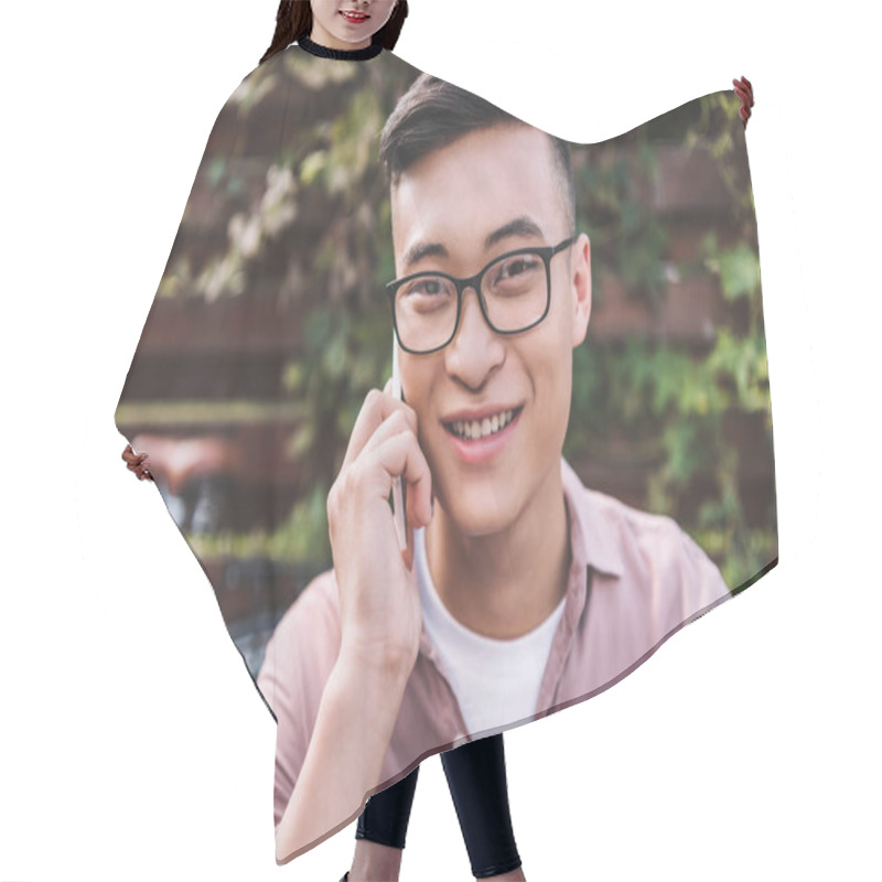 Personality  Portrait Of Smiling Asian Man In Eyeglasses Talking On Smartphone Hair Cutting Cape