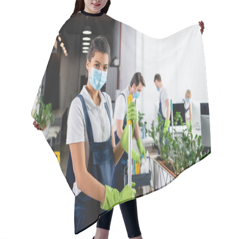 Personality  African American Cleaner In Medical Mask Holding Mop While Colleagues Working On Blurred Background In Office  Hair Cutting Cape