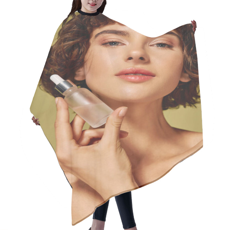 Personality  A Young Woman Holds A Skincare Serum Close To Her Face, Radiating Confidence And Charm. Hair Cutting Cape