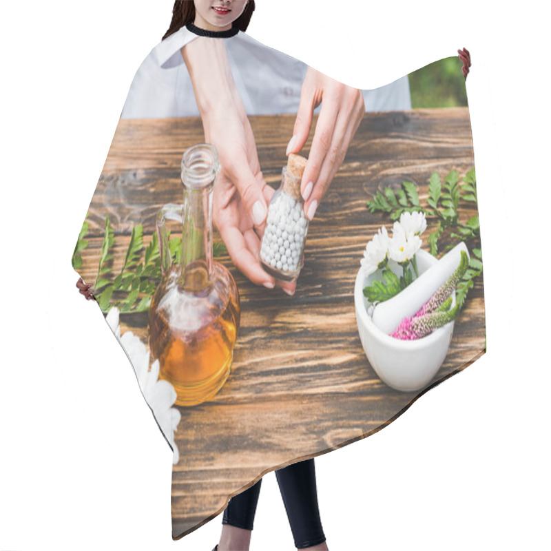 Personality  Cropped View Of Woman Holding Bottle With Pills Near Wooden Table With Plants  Hair Cutting Cape