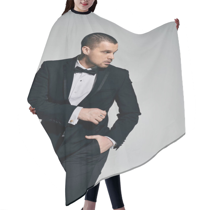 Personality  A Man In A Tuxedo Stands Confidently Against A Gray Background. Hair Cutting Cape