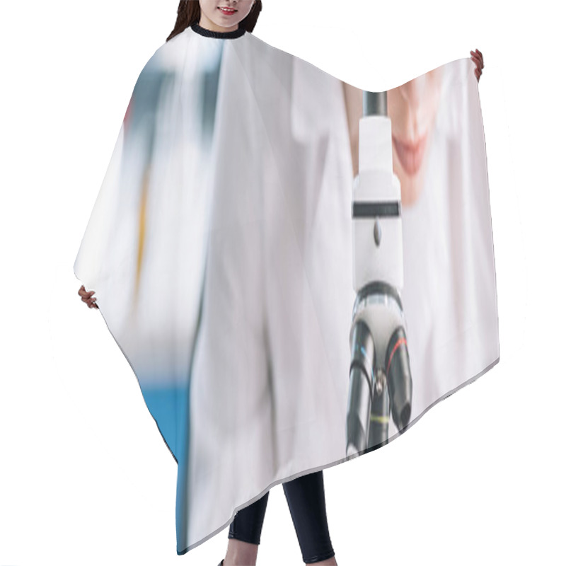 Personality  panoramic shot of immunologist looking through microscope in laboratory  hair cutting cape