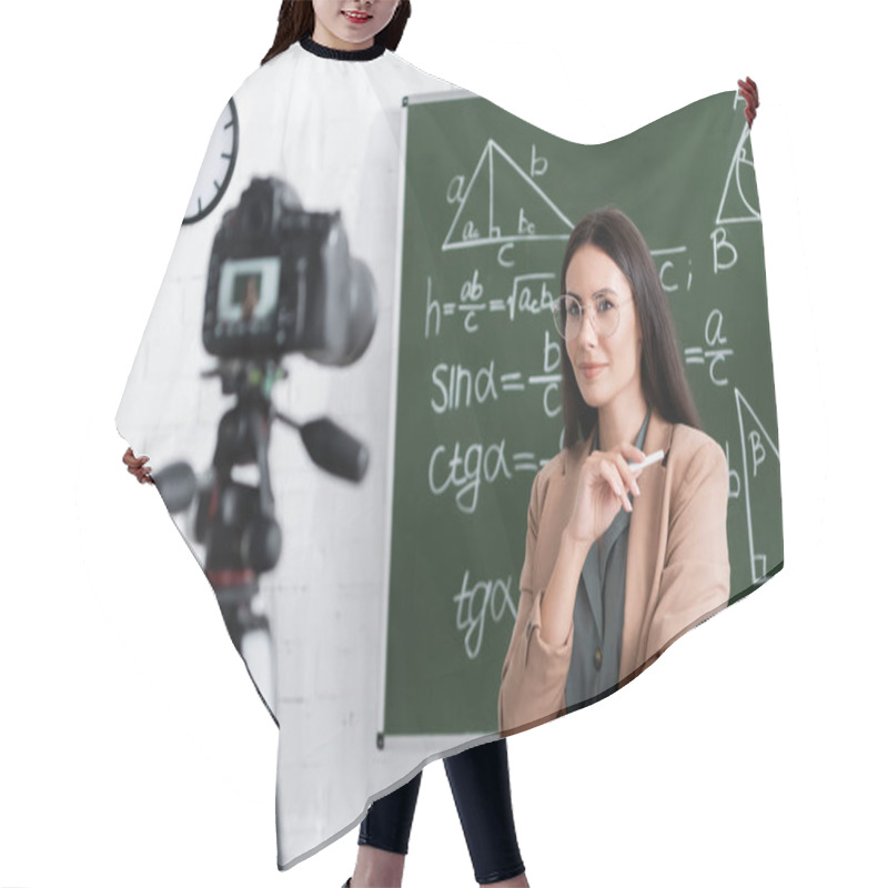 Personality  Teacher Holding Chalk Near Blurred Digital Camera And Chalkboard In Class  Hair Cutting Cape