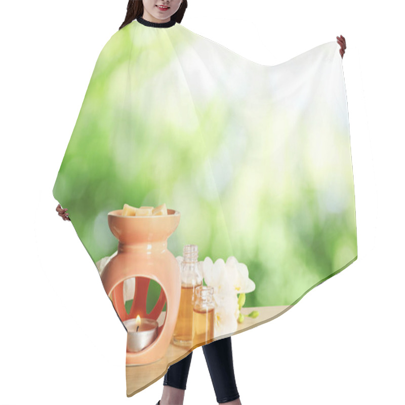 Personality  Composition With Aroma Lamp On Wooden Table Outdoors, Space For Text. Bokeh Effect Hair Cutting Cape