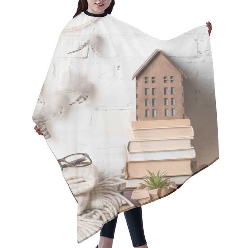 Personality  Books, Dream Catcher, Eyeglasses And Decorative Wooden House Near White Brick Wall  Hair Cutting Cape