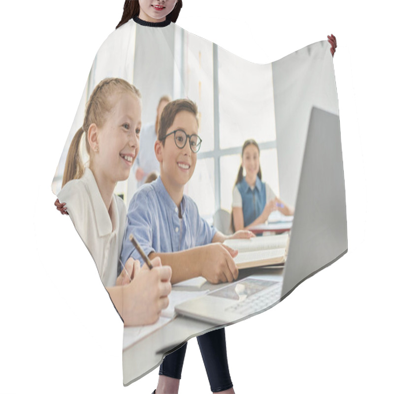 Personality  A Group Of Children Sitting At A Table, Focused On A Laptop In A Bright Classroom. Hair Cutting Cape