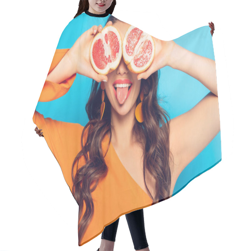 Personality  Cheerful Girl Covering Eyes With Pineapple Halves And Sticking Out Tongue On Blue Background Hair Cutting Cape