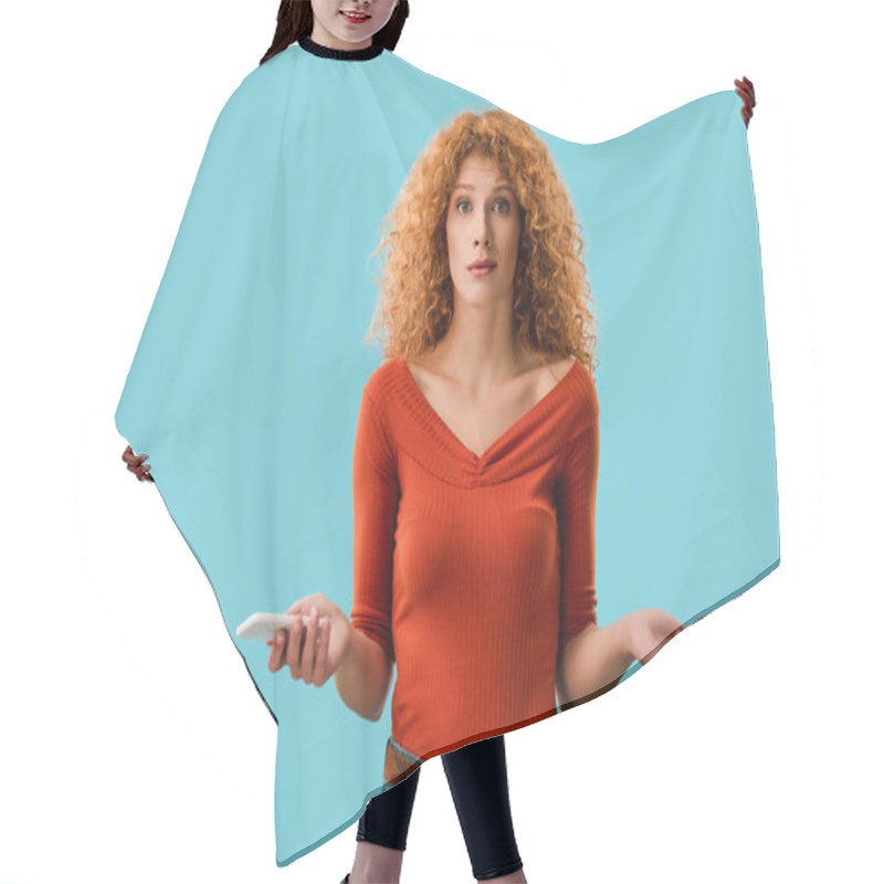 Personality  Curly Confused Woman Holding Smartphone Isolated On Blue Hair Cutting Cape