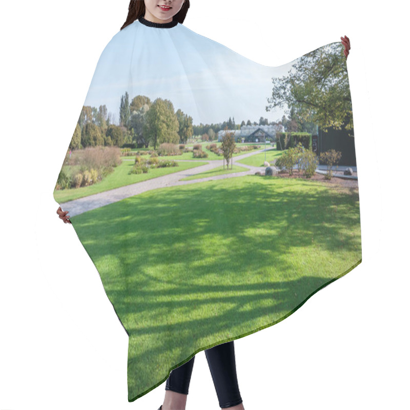 Personality  A Botanical Garden Scene With Green Lawns, Pathways, And A Large Greenhouse. Diverse Trees And Shrubs Are Set Against A Clear Blue Sky. Hair Cutting Cape