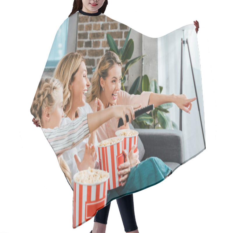 Personality  Excited Child With Mother And Grandmother Watching Movie On Couch At Home With Buckets Of Popcorn And Pointing At Screen Hair Cutting Cape