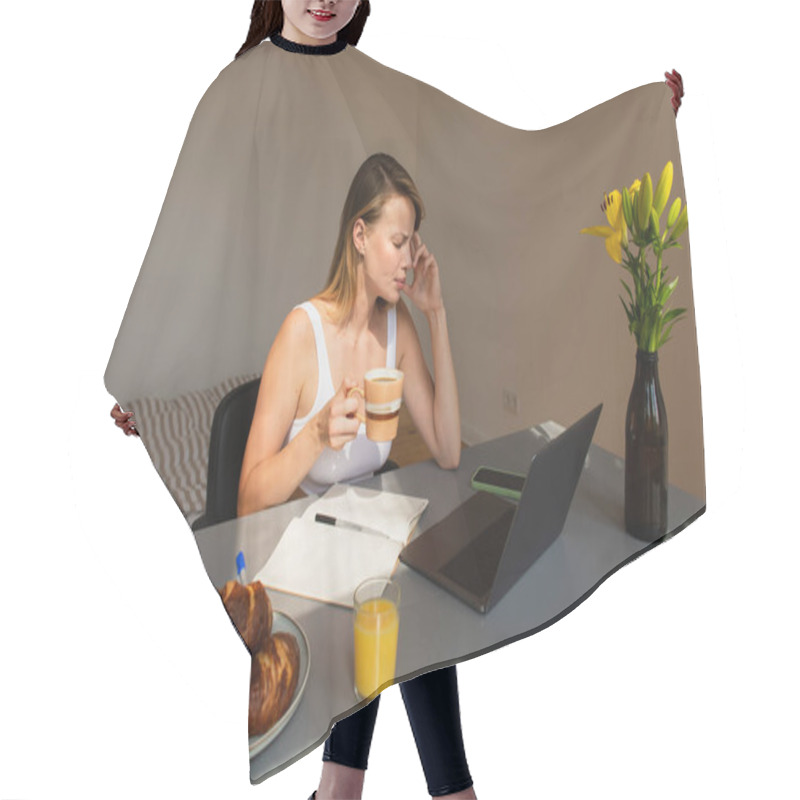 Personality  Side View Of Freelancer Holding Cup While Suffering From Headache Near Devices And Breakfast At Home  Hair Cutting Cape