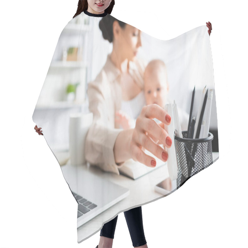 Personality  Selective Focus Of Mother Reaching Stationery While Holding In Arms Cute Infant Son  Hair Cutting Cape