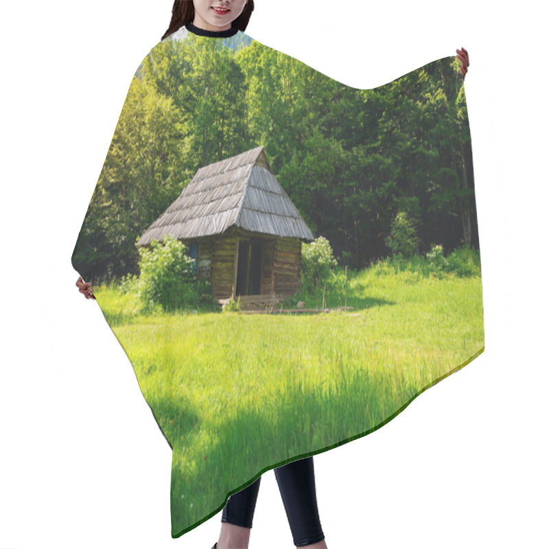 Personality  Old Wooden Hut On A Green Mountain Meadow Against A Background Of Trees - A Beautiful Sunny Evening In Nature. Hair Cutting Cape