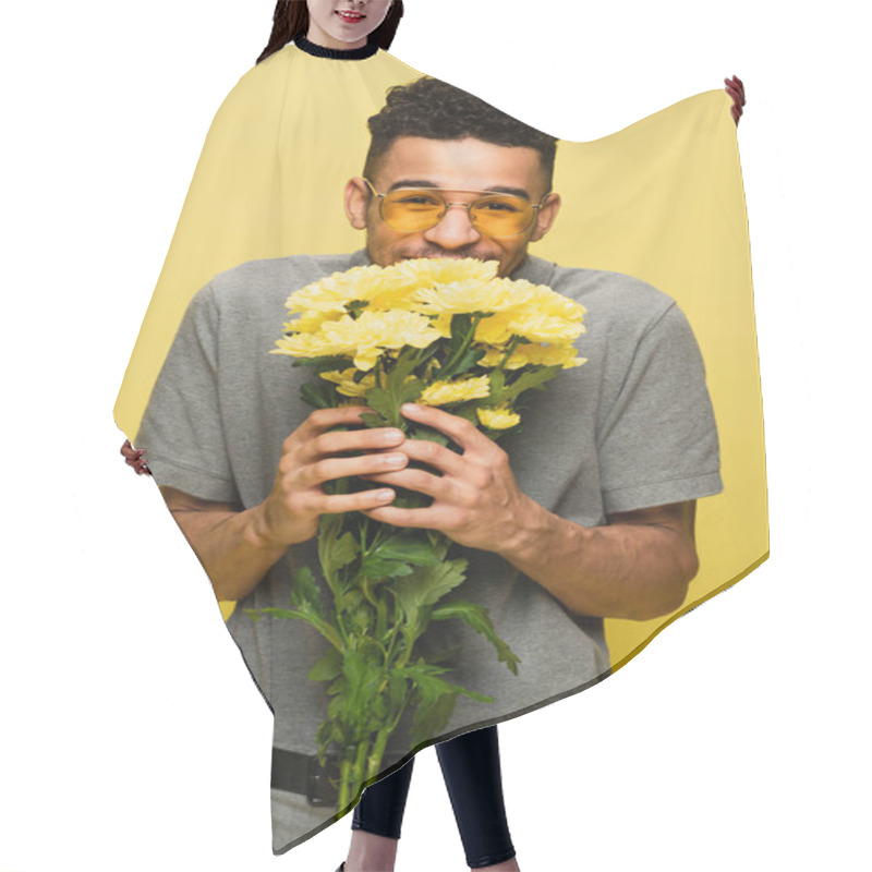 Personality  Happy African American Man In Sunglasses And Grey Tennis Shirt Holding Bouquet Of Flowers Isolated On Yellow  Hair Cutting Cape