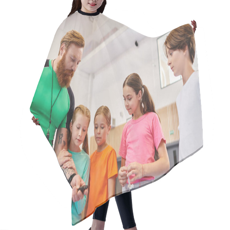 Personality  A Diverse Group Of Children Encircle A Man Holding A Basketball, As He Instructs Them In A Bright, Lively Classroom Setting. Hair Cutting Cape