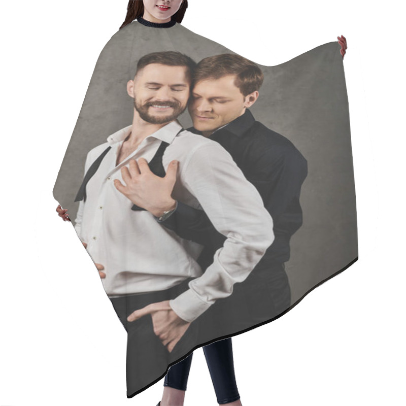 Personality  Two Men In Dapper Suits Embrace Lovingly In A Studio Setting. Hair Cutting Cape