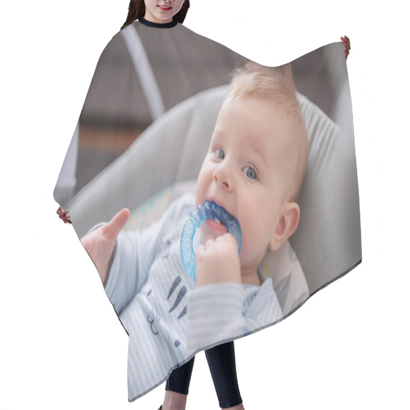 Personality  Head Shot Of Adorable Baby Boy Lying In Rocker Chair And Biting Teether. Hair Cutting Cape