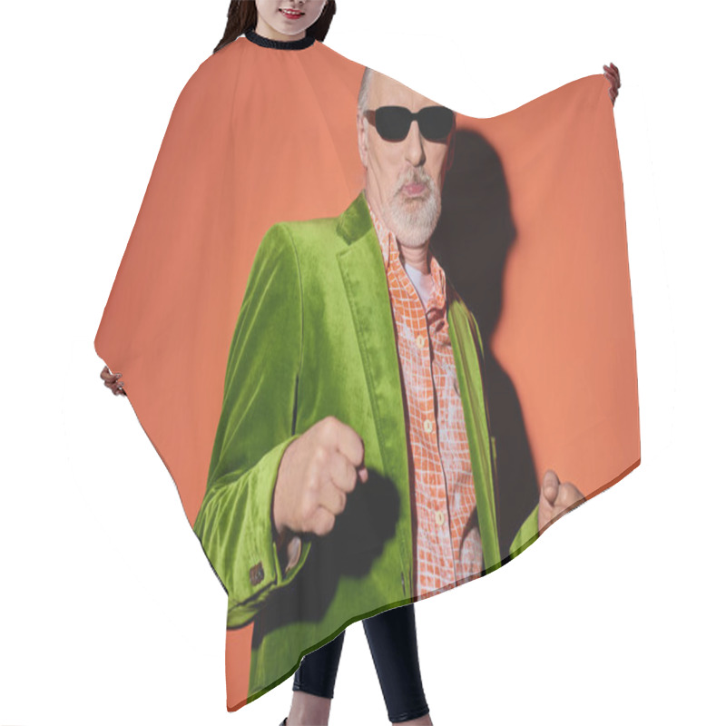 Personality  Cool Senior Man In Dark Sunglasses, Trendy Shirt And Green Velour Blazer Pouting Lips And Dancing While Having Fun On Red And Orange Background With Shadow, Happy Aging Concept Hair Cutting Cape