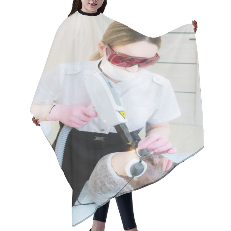 Personality  The Cosmetician Girl In Goggles Makes The Procedure Of Carbon Peeling With The Help Of A Cosmetology Laser. Carbon Face Peeling Procedure. Laser Pulses Clean Skin Of The Face. Hardware Cosmetology Hair Cutting Cape