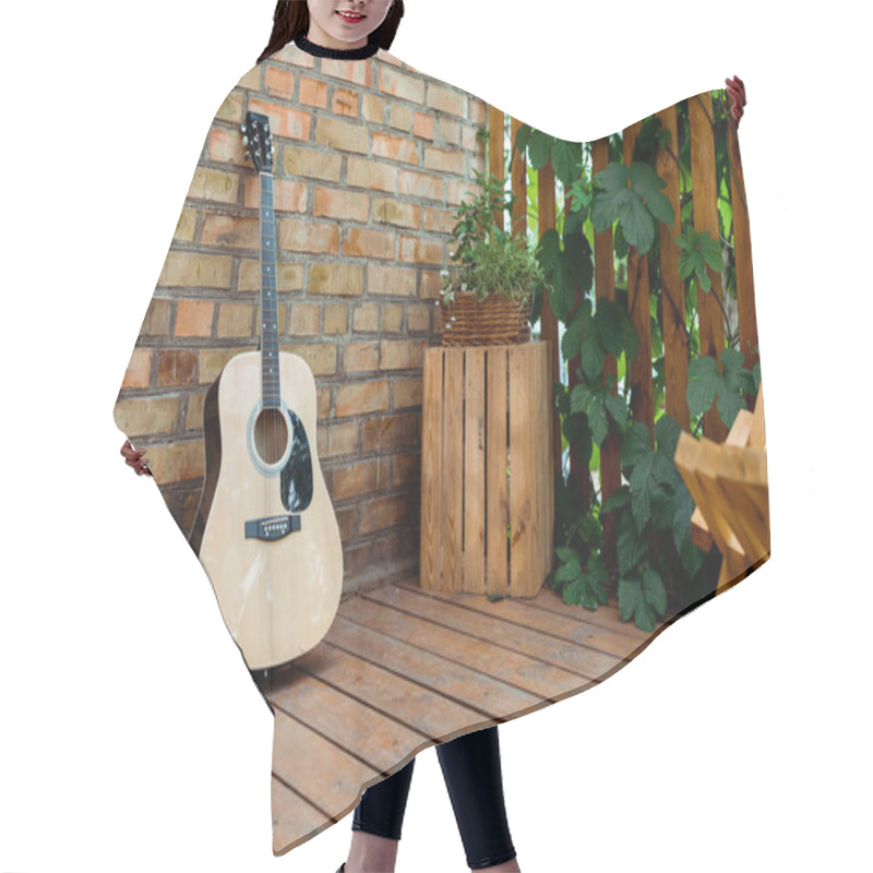 Personality  Selective Focus Of Acoustic Guitar Near Brick Wall And Wooden Fence With Green Leaves  Hair Cutting Cape