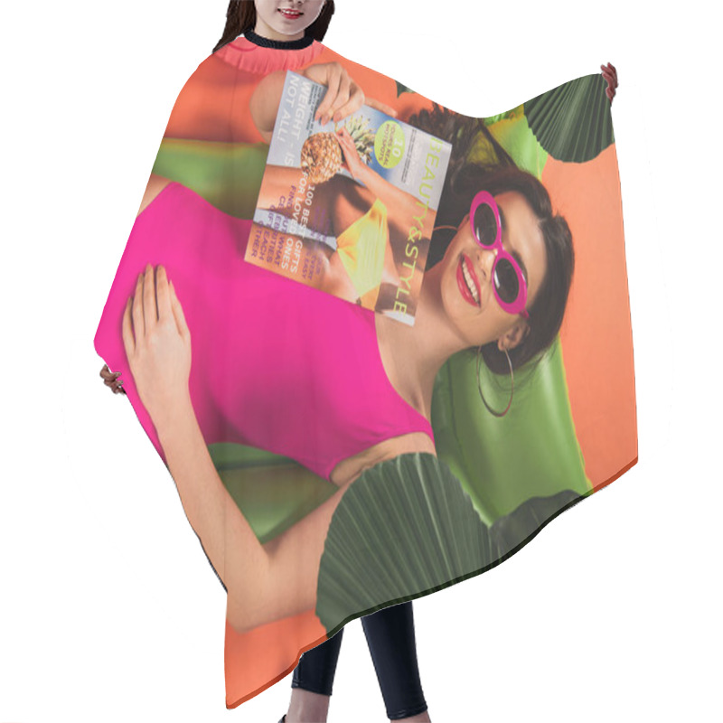 Personality  Top View Of Happy Young Woman In Sunglasses And Swimsuit Lying On Inflatable Mattress With Magazine Near Green Palm Leaves On Orange Hair Cutting Cape