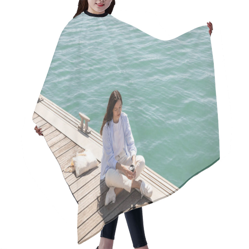 Personality  High Angle View Of Woman Holding Paper Cup While Sitting On Pier Near Canvas Bag Hair Cutting Cape