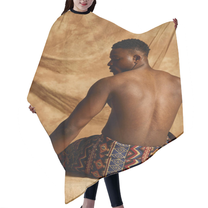 Personality  A Young Handsome African American Man Poses Topless, Exuding Confidence And Charm. He Is Seated On A Textured Surface, Dressed In A Patterned Wrap, With A Neutral Backdrop Enhancing His Features. Hair Cutting Cape