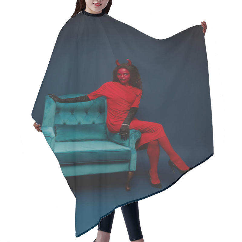 Personality  The Enchanting Woman, Dressed In A Vivid Red Costume, Strikes A Pose On A Teal Armchair. Hair Cutting Cape